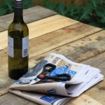 You will need an old newspaper, scissors and a bottle of wine or a soft drink can