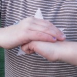 Using hand actions to demonstrate planting a seed and covering it with dirt